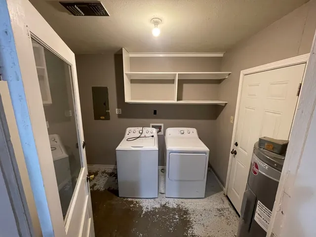Laundry room before: open shelves and a bare concrete floor