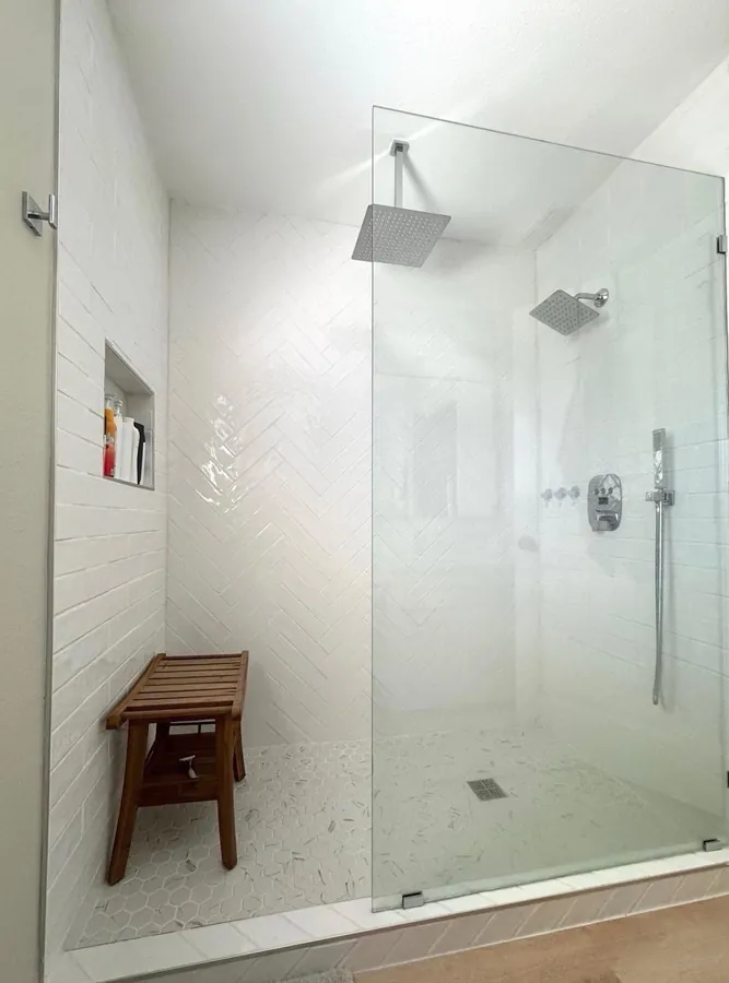 Walk-in tile shower with a frameless glass panel