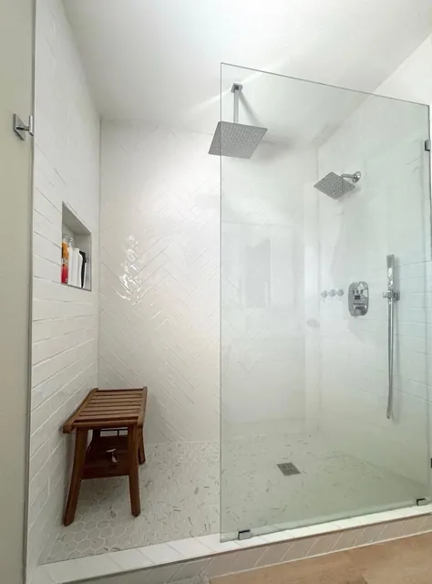 Walk-in tile shower with a frameless glass panel
